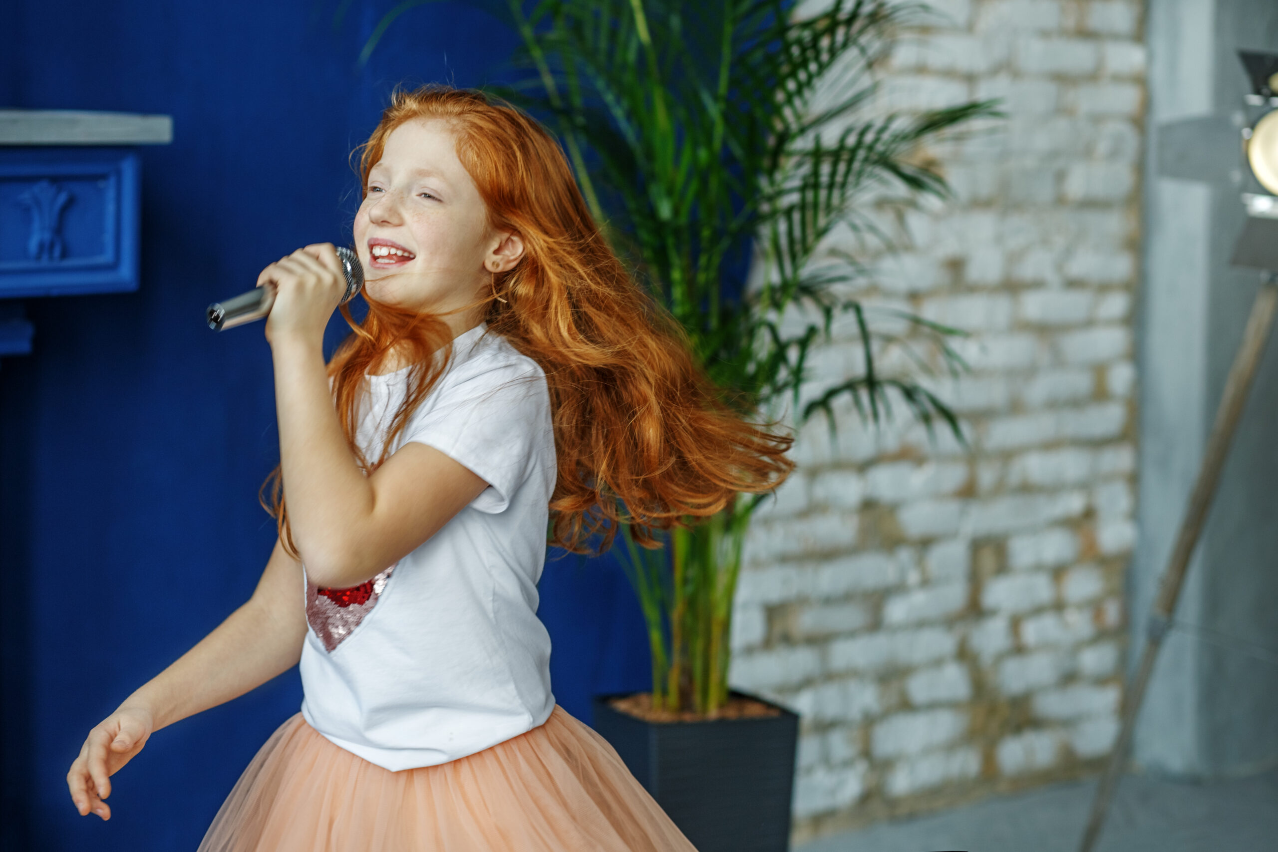 The child sings the song in the microphone.